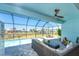 This screened-in pool area offers beautiful views of the surrounding lake and landscaping at 13284 Amaryllis Cir, Port Charlotte, FL 33981