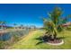The lush backyard of this waterfront property is framed by beautiful trees and landscaping at 13284 Amaryllis Cir, Port Charlotte, FL 33981