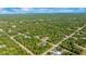 Wide aerial shot showing a property nestled in a vast forest and near neighborhood streets in a rural area at 13325 Ketridge Ave, Port Charlotte, FL 33953
