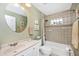 Bathroom with a shower-tub combination, updated vanity, and a decorative round mirror at 13325 Ketridge Ave, Port Charlotte, FL 33953