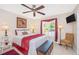 Cozy bedroom featuring a ceiling fan, shuttered windows with drapes, and stylish furnishings at 13325 Ketridge Ave, Port Charlotte, FL 33953