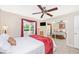 Comfortable bedroom with mirrored closet doors, ceiling fan, and view of the lush, landscaped outdoors at 13325 Ketridge Ave, Port Charlotte, FL 33953
