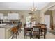 Cozy dining area featuring tile floors, stylish lighting, and seamless transition to the kitchen at 13325 Ketridge Ave, Port Charlotte, FL 33953