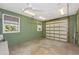 A well-lit garage space featuring a clean concrete floor, neutral green walls, and a functional roll-up door at 13325 Ketridge Ave, Port Charlotte, FL 33953