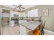 Bright kitchen features white cabinets, stainless steel appliances, and a cozy breakfast bar at 13325 Ketridge Ave, Port Charlotte, FL 33953