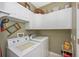 Functional laundry room equipped with washer, dryer, and plenty of overhead cabinet space for supplies at 13325 Ketridge Ave, Port Charlotte, FL 33953