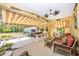 Spacious outdoor patio area with an awning, comfortable seating, bar, and relaxing hot tub at 13325 Ketridge Ave, Port Charlotte, FL 33953