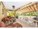 Covered patio area with comfortable seating, a bar, hot tub, and screened-in enclosure at 13325 Ketridge Ave, Port Charlotte, FL 33953