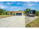 A bright yellow single-story house with a long driveway, featuring a parked RV on a gravel pad to the side at 13325 Ketridge Ave, Port Charlotte, FL 33953