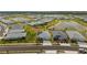 Aerial view of a residential community with numerous single-Gathering homes, serene lakes, and lush green spaces at 16440 Marsh Ln, Punta Gorda, FL 33982
