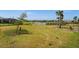 Expansive backyard with lush green grass, a serene pond, and views of neighboring homes provides a tranquil retreat at 16440 Marsh Ln, Punta Gorda, FL 33982