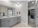 Well-lit bathroom with double vanity and storage, next to closet space with ample shelving for storage at 16440 Marsh Ln, Punta Gorda, FL 33982