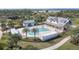A stunning community pool is surrounded by palm trees and a modern clubhouse in a resort setting at 16440 Marsh Ln, Punta Gorda, FL 33982