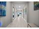 Long hallway with tile floors, recessed lighting, and contemporary artwork adorning the walls at 16440 Marsh Ln, Punta Gorda, FL 33982