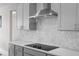 Modern kitchen featuring stainless steel appliances, a sleek range hood, and an electric cooktop at 16440 Marsh Ln, Punta Gorda, FL 33982