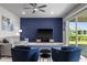 Cozy living room with a blue accent wall, neutral furniture, and sliding glass doors to outdoor patio at 16440 Marsh Ln, Punta Gorda, FL 33982