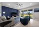 Comfortable living room with contemporary blue accent wall, fan, and sliding glass doors to outdoor patio at 16440 Marsh Ln, Punta Gorda, FL 33982