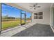 Relax on the screened patio, featuring a ceiling fan and picturesque views of the lush greenery and expansive backyard at 16440 Marsh Ln, Punta Gorda, FL 33982