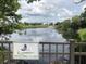 A sign for Spoonbill Lake is visible over a railing with the lake and trees in the background at 17304 Vagabond Cir, Punta Gorda, FL 33955