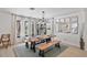 Inviting dining room featuring a rustic wood table and bench seating, with views of the outdoors through expansive windows at 17304 Vagabond Cir, Punta Gorda, FL 33955
