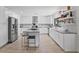 Bright, modern kitchen with white cabinets, granite counters, stainless appliances, and a center island with stools at 17304 Vagabond Cir, Punta Gorda, FL 33955