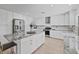 Modern white kitchen featuring stainless steel appliances, granite countertops, and a kitchen island with bar seating at 17304 Vagabond Cir, Punta Gorda, FL 33955