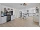 Open concept kitchen with white cabinetry, granite countertops, stainless steel appliances, wine bar, and wood flooring at 17304 Vagabond Cir, Punta Gorda, FL 33955