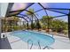 View of the screened in pool, surrounded by lush landscape at 17304 Vagabond Cir, Punta Gorda, FL 33955