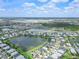 Wide aerial view of a community featuring a mix of homes and recreational areas by the lake at 17620 Winding Wood Ln, Punta Gorda, FL 33982