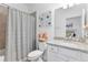 Stylish bathroom featuring granite counters, gray shower curtain, and decorative floral artwork at 17620 Winding Wood Ln, Punta Gorda, FL 33982