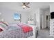 Cozy primary bedroom featuring neutral tones, ceiling fan, waterfront views, and an attached bathroom at 17620 Winding Wood Ln, Punta Gorda, FL 33982