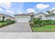 Well-maintained single-story home with lush landscaping, brick-paved driveway and attached two-car garage at 17620 Winding Wood Ln, Punta Gorda, FL 33982