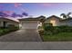 Charming single-story home with a brick-paved driveway and attached two-car garage, surrounded by green landscaping at 17620 Winding Wood Ln, Punta Gorda, FL 33982