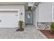 Welcoming front entrance features a light blue door, brick-paved walkway, and manicured landscaping at 17620 Winding Wood Ln, Punta Gorda, FL 33982