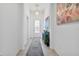 Elegant hallway featuring tile flooring, a stylish console table, and a view of the front door at 17620 Winding Wood Ln, Punta Gorda, FL 33982