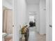 Hallway view showing bathroom and office entrances, with a decorative table and tile floors at 17620 Winding Wood Ln, Punta Gorda, FL 33982
