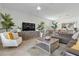 Bright living room with white chair, sectional sofa, ceiling fan, and decorative accents at 17620 Winding Wood Ln, Punta Gorda, FL 33982