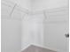 Empty white walk-in closet with carpet and metal shelving at 17620 Winding Wood Ln, Punta Gorda, FL 33982