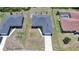 Aerial view of a home with a dark roof and a long driveway on a sunny day in a residential area at 18503 Ellen Ave, Port Charlotte, FL 33948