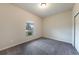 Empty bedroom showcasing gray carpet, a window, and a closet with sliding doors at 18503 Ellen Ave, Port Charlotte, FL 33948