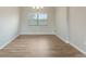 Bright dining area with wood-look flooring, modern light fixture, and window with blinds at 18503 Ellen Ave, Port Charlotte, FL 33948
