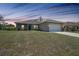 Exterior view of a single-story house with a well-manicured lawn and an attached two car garage at 18503 Ellen Ave, Port Charlotte, FL 33948