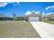 Exterior view of a single-story house with a well-manicured lawn and an attached two car garage at 18503 Ellen Ave, Port Charlotte, FL 33948