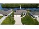 Aerial view of a beautifully landscaped waterfront property with lush greenery and a private boat dock at 19246 Moore Haven Ct, Port Charlotte, FL 33948