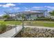 Home showcasing a screened in patio with access to the water, landscaping, and a dock at 19246 Moore Haven Ct, Port Charlotte, FL 33948