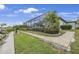 View of home featuring a screened in patio and beautifully landscaped yard at 19246 Moore Haven Ct, Port Charlotte, FL 33948