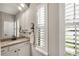 Well-lit bathroom with granite countertops, white cabinets, and plantation shutters for natural light at 19246 Moore Haven Ct, Port Charlotte, FL 33948