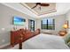 Comfortable bedroom featuring a king-size bed, tray ceiling, and serene views of the waterfront from the window at 19246 Moore Haven Ct, Port Charlotte, FL 33948