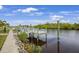 Dock leading out to a calm body of water with lush trees lining the banks under a partly cloudy sky at 19246 Moore Haven Ct, Port Charlotte, FL 33948