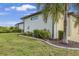 Well-maintained home exterior with a manicured lawn, mature trees, and an attached two-car garage at 19246 Moore Haven Ct, Port Charlotte, FL 33948